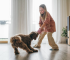 Young girl gently plays with her dog, teaching good behavior without a bark collar.