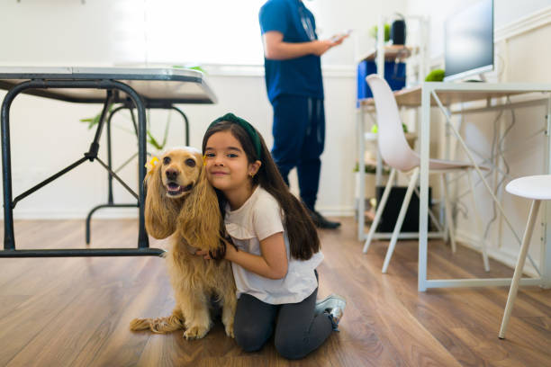A happy girl hugs her spaniel; gentle training methods are preferred over a bark collar.
